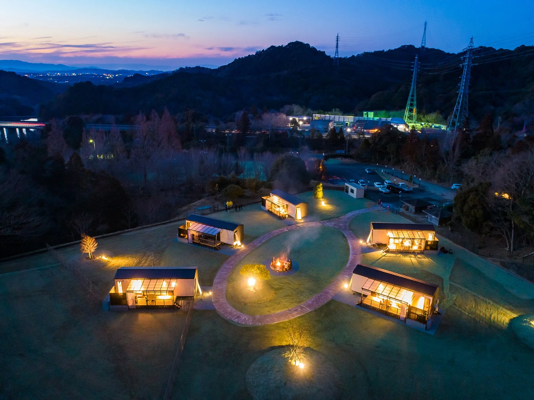 夕暮れ時のグランピング施設を上空から捉えた画像。