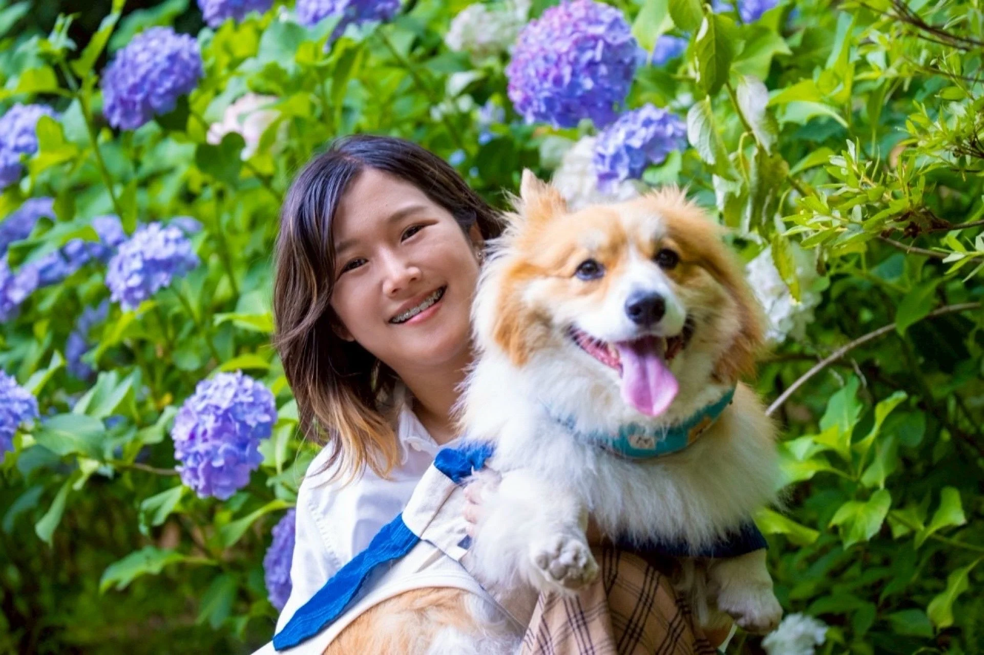 笑顔の女性が犬を抱く