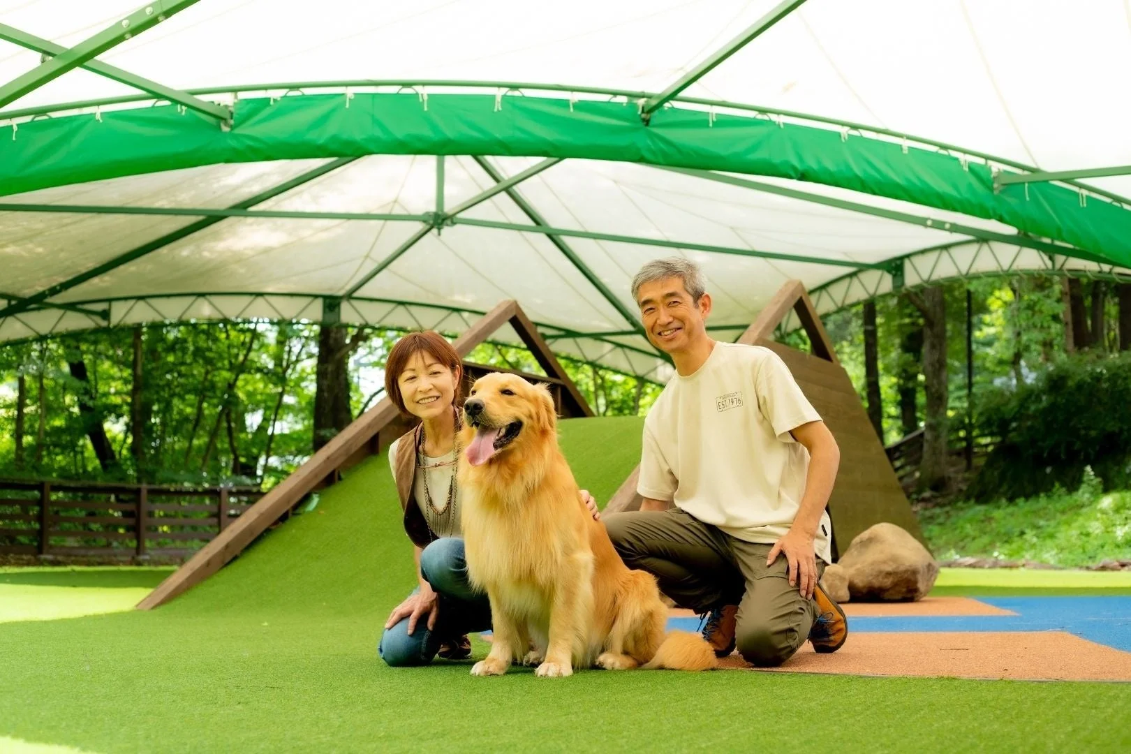 芝生広場で楽しむゴールデンレトリバーと飼い主